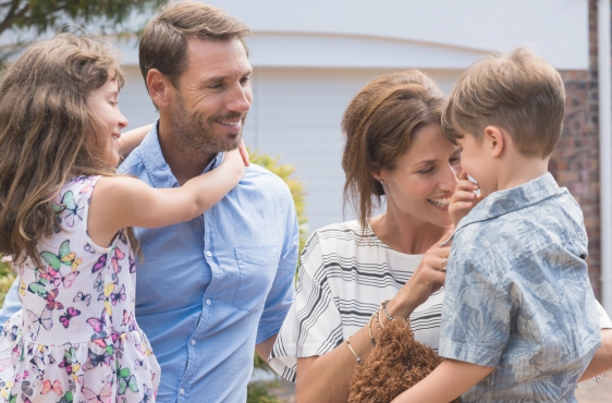 family standing in front of home secure knowing they have life insurance protection